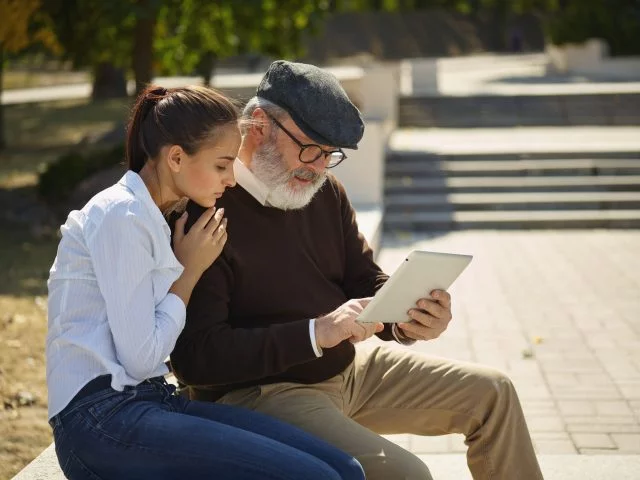 Woman and man in park looking at tablet